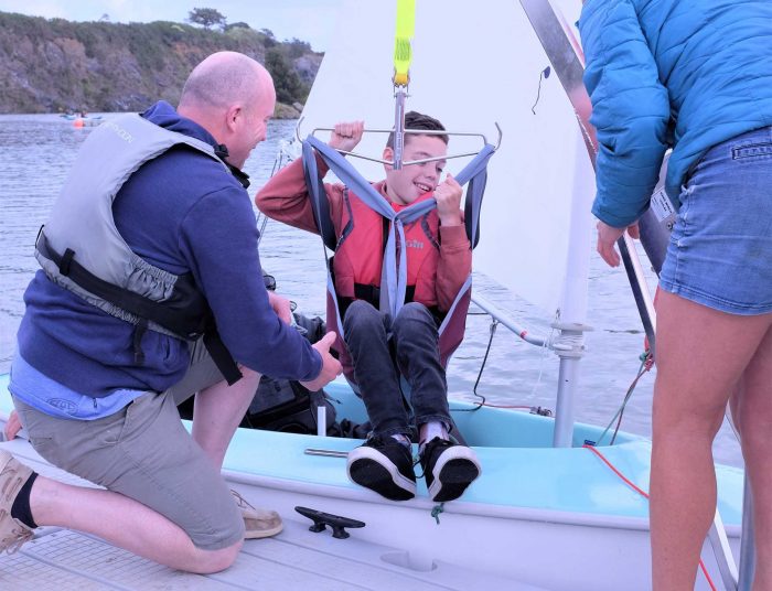 Child being hoisted into a dinghy