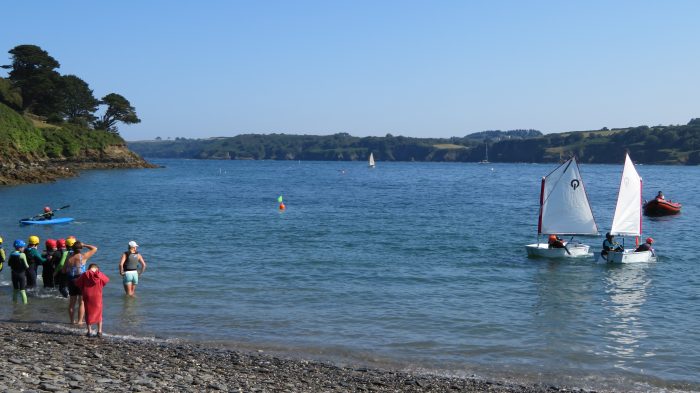 Parents launching little ones off in a dinghy